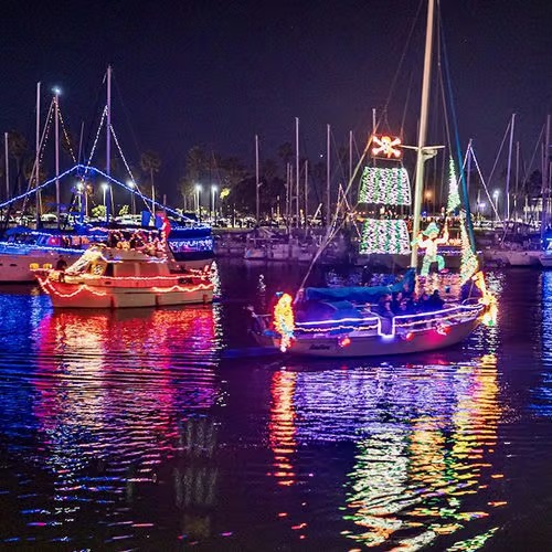 Sailboats decorated with holiday lights at a previous Ventura Harbor boat parade
